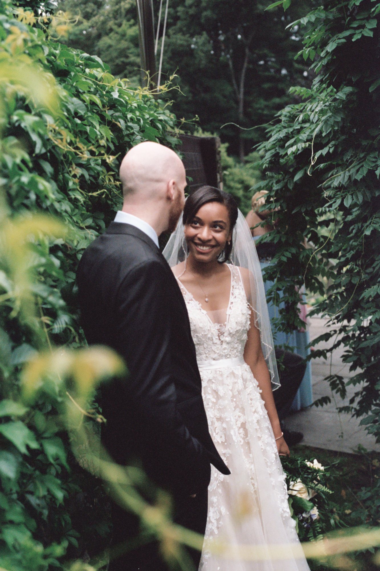 Bride smiling through greenery