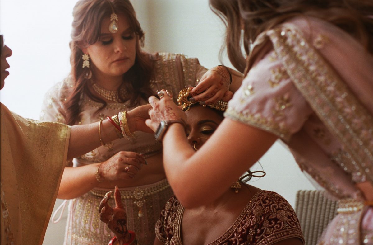 Bridesmaids placing headpiece